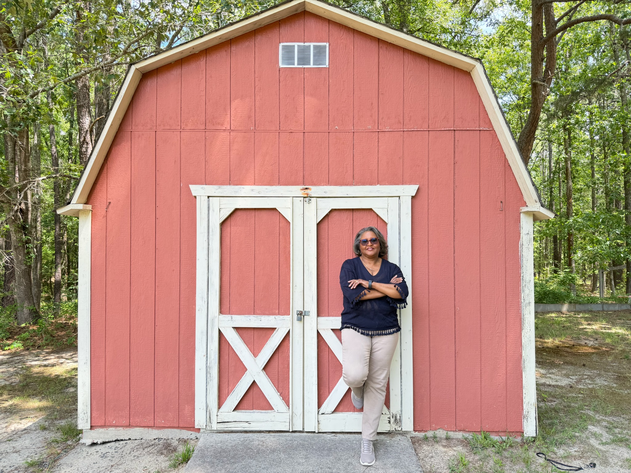 Dr. LaHoma Smith Romocki standing confidently in front of a red barn in Granville County, NC